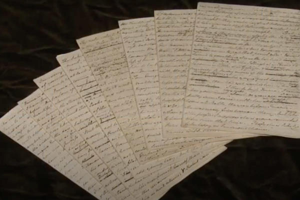 8 pages of a handwritten manuscript laid out in a fan